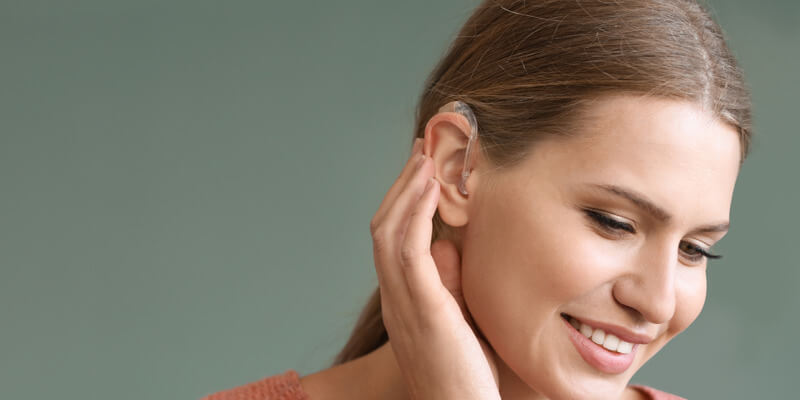 Smiling woman with hearing aid in her ear