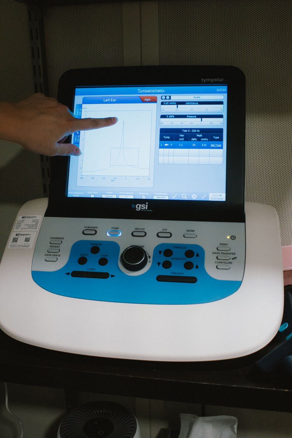 A Audiologist pointing at a screen showing a patients hearing aid evaluation